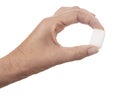 White sugar cube held between fingers  on white background. One lump of sugar. Royalty Free Stock Photo