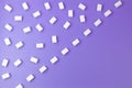 White sugar cubes arranged in diagonal lines on purple background Royalty Free Stock Photo