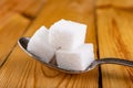White sugar cubes. Sweetener for kitchen dishes on a wooden table
