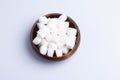 White sugar cubes in a wooden cup on a white background Royalty Free Stock Photo