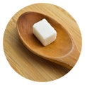White and sugar cubes in wooden spoon on bamboo cutting board Royalty Free Stock Photo