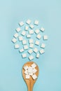 White sugar cubes on a wooden spoon and on a blue background Royalty Free Stock Photo