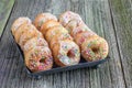 White sugar glazed mini donuts on a sheet metal tray