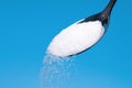 White Sugar spoon blue background. Royalty Free Stock Photo