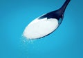 White Sugar spoon blue background. Royalty Free Stock Photo