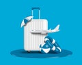 white suitcase or suitcase placed on water and on top of it is an umbrella there is plane in front and there was inflatable ball