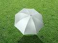 The white sun umbrella place on green grass golf course using for sun protection Royalty Free Stock Photo