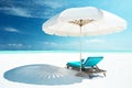 A white sun umbrella and sun loungers on the white sand of the beach Royalty Free Stock Photo