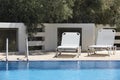 White sunbeds and swimming pool in summer Royalty Free Stock Photo