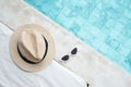 White sunglasses and hat near swimming pool in luxury hotel. Summer travel, vacation, holiday and weekend concept Royalty Free Stock Photo