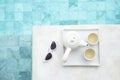 White sunglasses and hot tea pot near swimming pool in luxury hotel. Summer travel, vacation, holiday and weekend concept Royalty Free Stock Photo