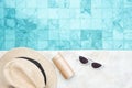 White sunglasses, sunscreen bottle and hat near swimming pool in luxury hotel. Summer travel, vacation, holiday and weekend Royalty Free Stock Photo