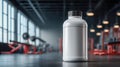 A clean white supplement bottle stands out prominently within the context of a spacious, modern gym setting. Royalty Free Stock Photo