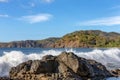 White Surf Approaching a Rock