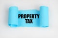 On a white surface, a blue scroll of paper with the inscription - PROPERTY TAX