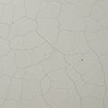 A white surface with an irregular pattern of fine cracks, resembling a network of Royalty Free Stock Photo