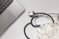 white surface with a laptop, disposable gloves and a stethoscope aerial view, concept of medicine and doctor Royalty Free Stock Photo