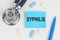 On a white surface lie pills, a stethoscope and stickers with the inscription - Syphilis