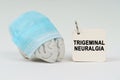 On a white surface next to the brain there is a notepad with the inscription - Trigeminal neuralgia Royalty Free Stock Photo