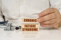 On a white surface, a stethoscope and wooden plates with the inscription - chronic fatigue syndrome