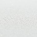 A white surface with thousands of tiny, evenly distributed silver dots creates a Royalty Free Stock Photo