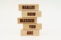 On a white surface are wooden blocks with the inscription - Realize How Blessed You Are