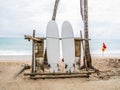 White surfboard abandoned on an empty sandy beach with waves in distance. Royalty Free Stock Photo