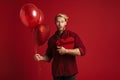 White surprised man posing with balloons and heart gift box