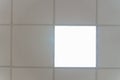 White suspended ceiling with square fluorescent lights in an office space. Design and details of a modern ceiling and lighting