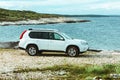 white suv car at rocky seaside. off road car travel concept Royalty Free Stock Photo