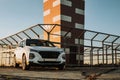 White compact SUV car with sport and modern design parked on concrete road by the sea near the beach at sunset Royalty Free Stock Photo