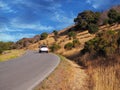 A white SUV driving on a scenic country road