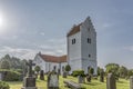 A white swedish church with a high tower, in the soft sunshine