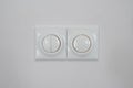 White switch on white wall. Regulator of electric switch of candle-power Royalty Free Stock Photo