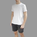 White t shirt and black shorts on a young man template on grey b Royalty Free Stock Photo