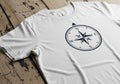 White T-shirt featuring a black compass rose design, with cardinal directions (N, E, S, W) marked. Royalty Free Stock Photo