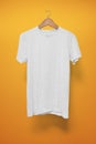 White T-Shirt on a hanger against an orange background Royalty Free Stock Photo