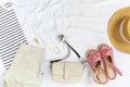 White t shirt, shorts, straw hat, sandals, bag on white background. Top view of woman`s spring casual outfit. Simple basic summer. Royalty Free Stock Photo