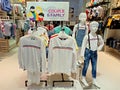 White t-shirts display arrangement of kids mannequins in the fashion store