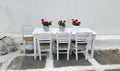 White table with beautiful floewers and chairs in a street restaurant in Mykonos island