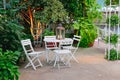 White table and chairs in beautiful garden. Royalty Free Stock Photo