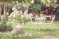 White table and chairs in beautiful garden. Vintage style pictures. Royalty Free Stock Photo