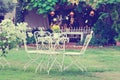 White table and chairs in beautiful garden. Vintage style pictures. Royalty Free Stock Photo