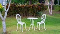 White table and chairs in a garden Royalty Free Stock Photo