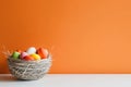 On a white table with a cream background, a basket of Easter eggs is displayed under studio lighting. The eggs are Royalty Free Stock Photo