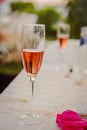 White table decorated with pink napkin and a glass of sparkling wine. Royalty Free Stock Photo