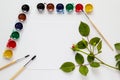 White table desk, top view, flat lay. Watercolor, brushes, paper, rose flowers Royalty Free Stock Photo