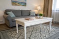 White table in front of grey settee in stylish apartment Royalty Free Stock Photo