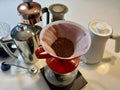 professional coffee shop On white table in kitchen there are different devices for brewing craft coffee Nearby grows a