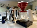 professional coffee shop On white table in kitchen there are different devices for brewing craft coffee Nearby grows a